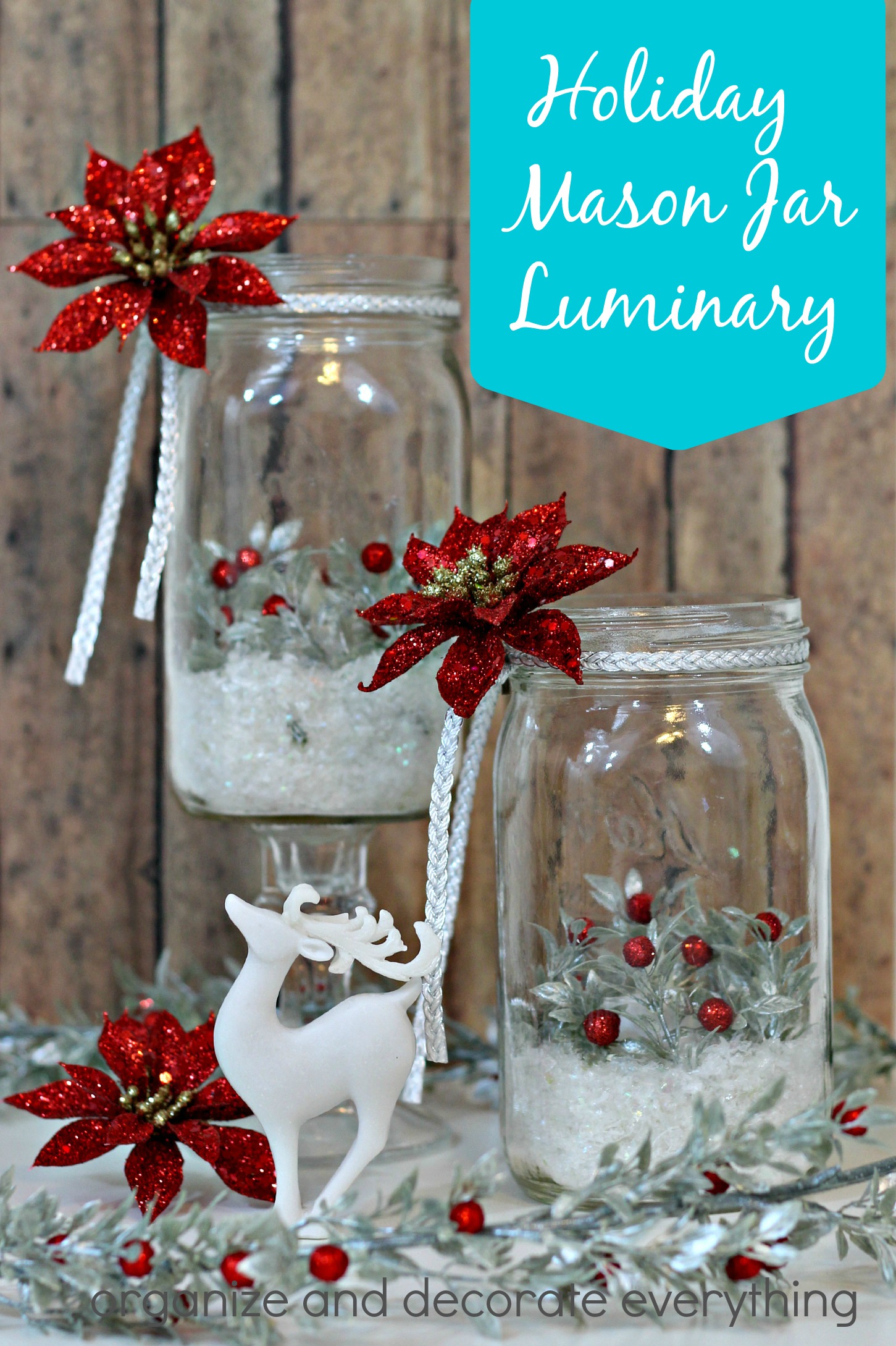 Holiday Mason Jar Luminary Scene Two mason jar luminaries with faux snow, silver berry sprigs and red glitter poinsettias beside a white deer figurine